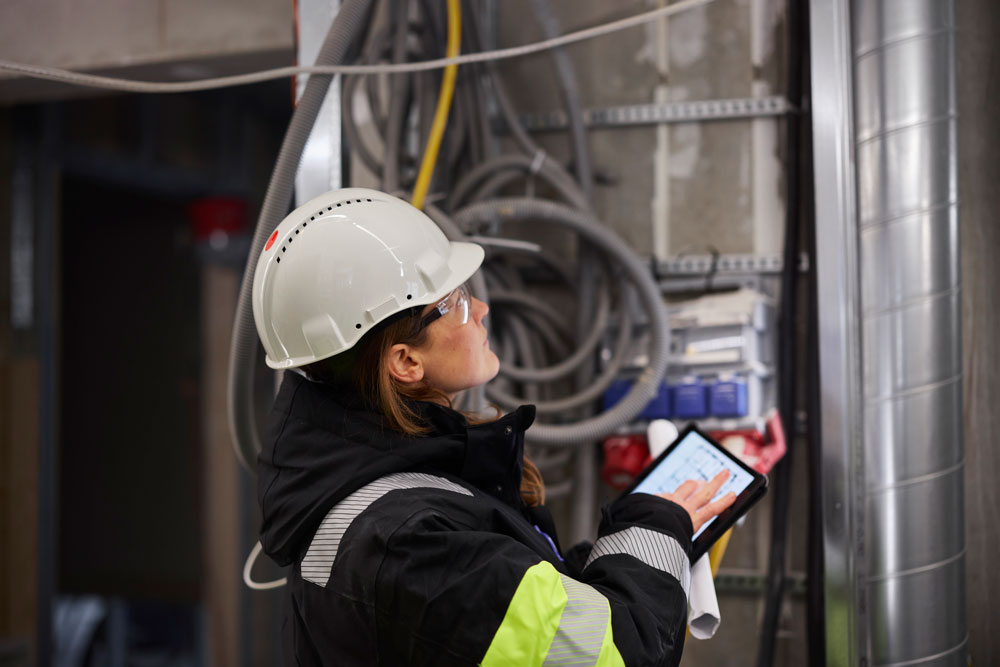 Ingenjör som använder en surfplatta på en byggarbetsplats.